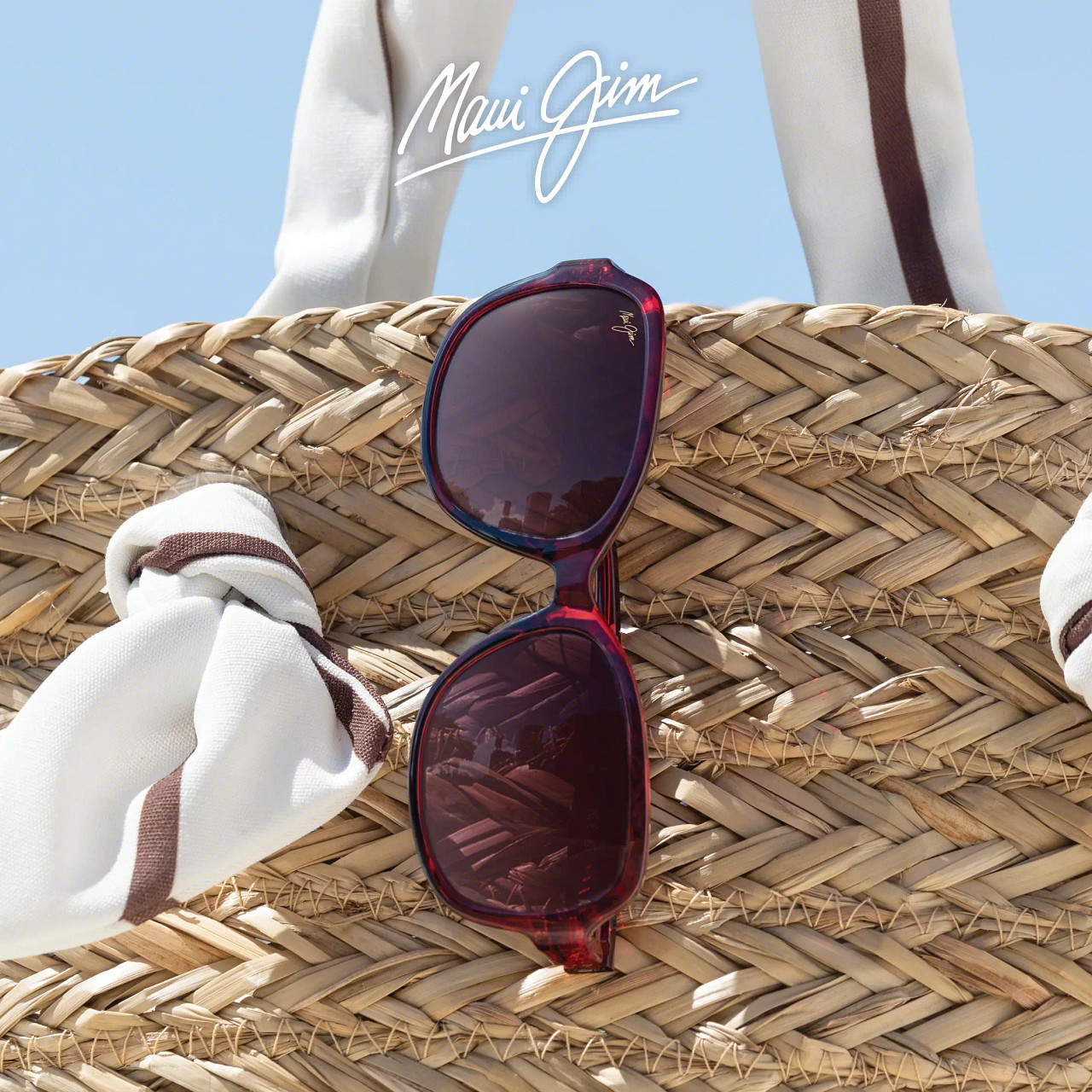 Maui Jim solglasögon i röd ton på strandväska